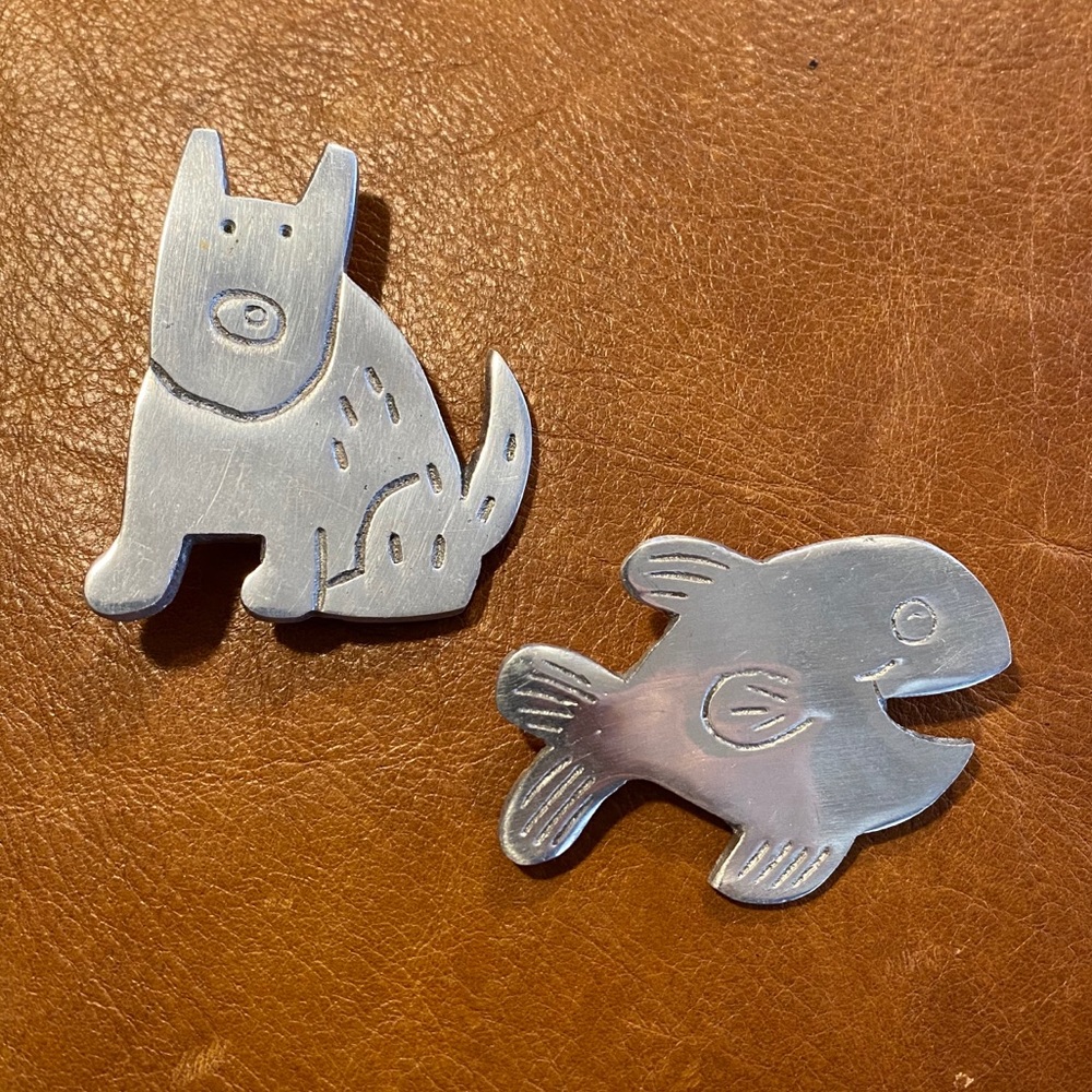 Silver metal dog and fish pins.
